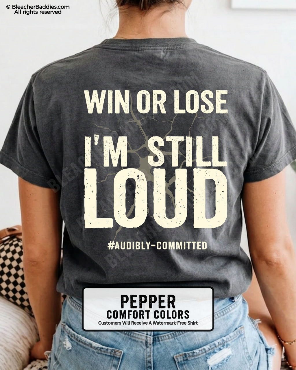 Woman wearing a pepper Comfort Colors t-shirt shown from the back featuring a large distressed cream graphic that reads “Win or Lose I’m Still Loud #Audibly Committed.”