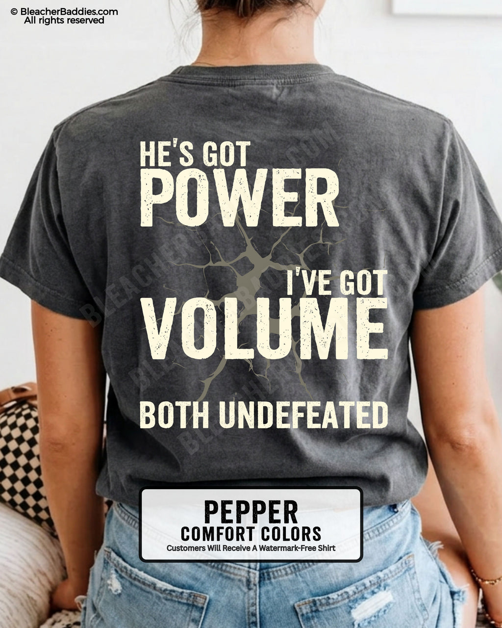Back view of PEPPER Comfort Colors football mom game day shirt reading “He’s Got Power I’ve Got Volume Both Undefeated,” close-up fit on woman wearing denim shorts