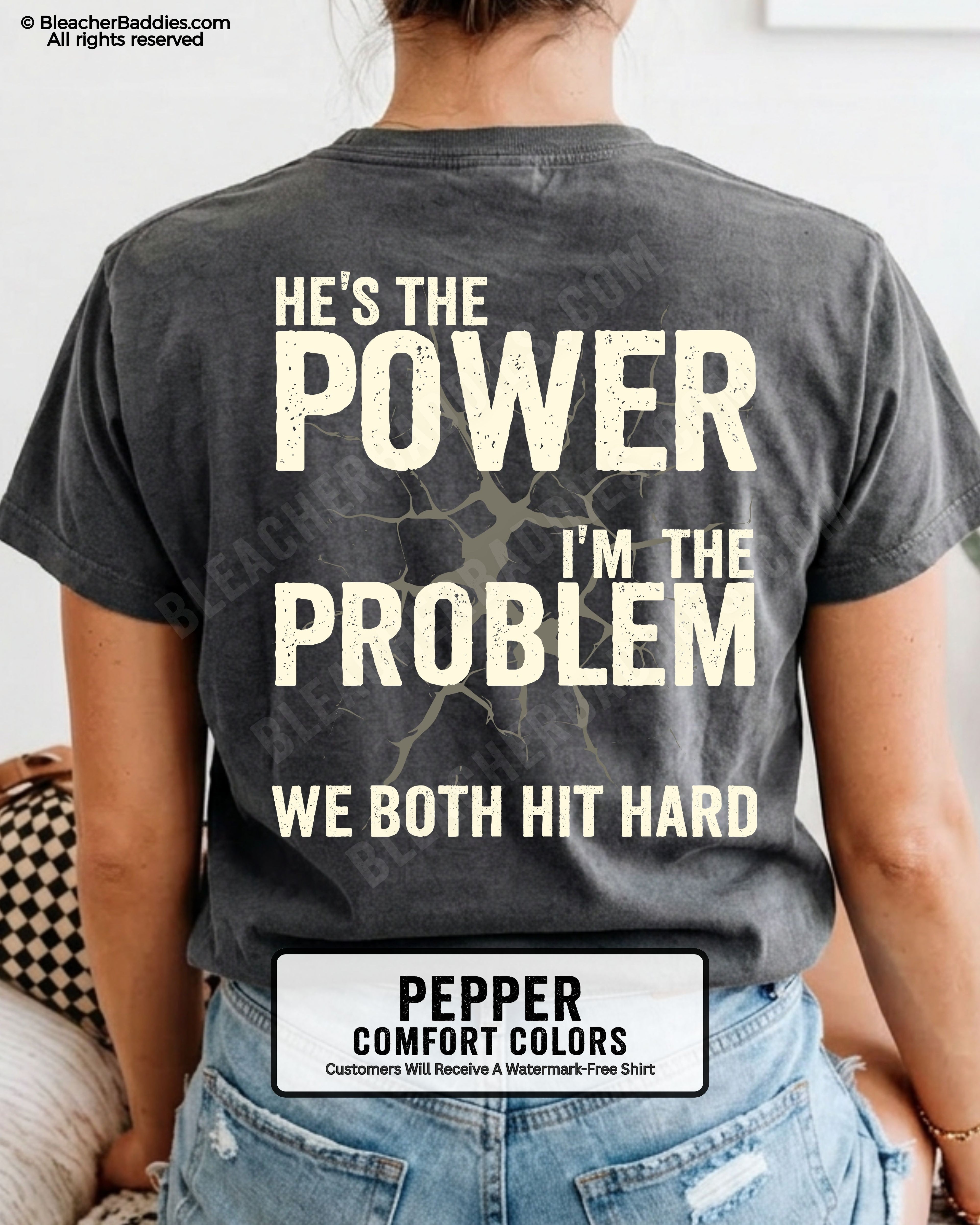 Back view of pepper Comfort Colors football mom game day shirt reading “He’s the Power I’m the Problem We Both Hit Hard,” close-up fit on woman wearing denim shorts