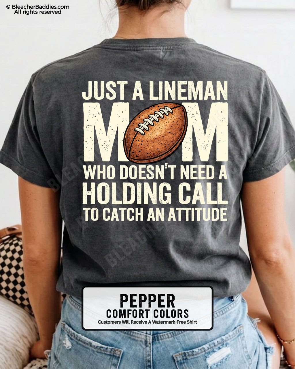 back view of woman wearing a pepper Comfort Colors lineman mom football shirt featuring bold back design that says “Just a lineman mom who doesn’t need a holding call to catch an attitude”