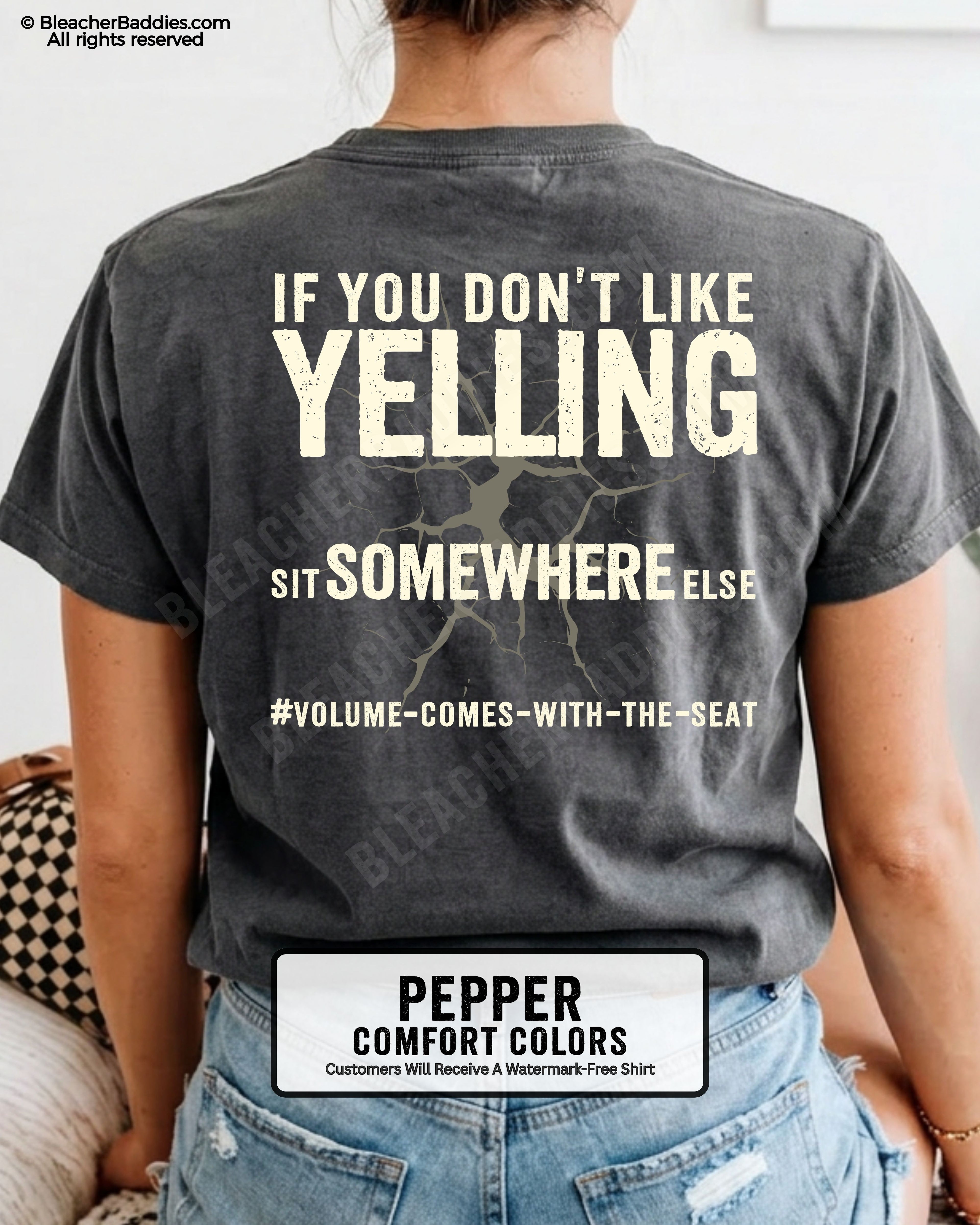 Woman wearing a pepper Comfort Colors t-shirt shown from the back featuring a large distressed cream graphic that reads “If You Don’t Like Yelling Sit Somewhere Else #Volume Comes With the Seat.”