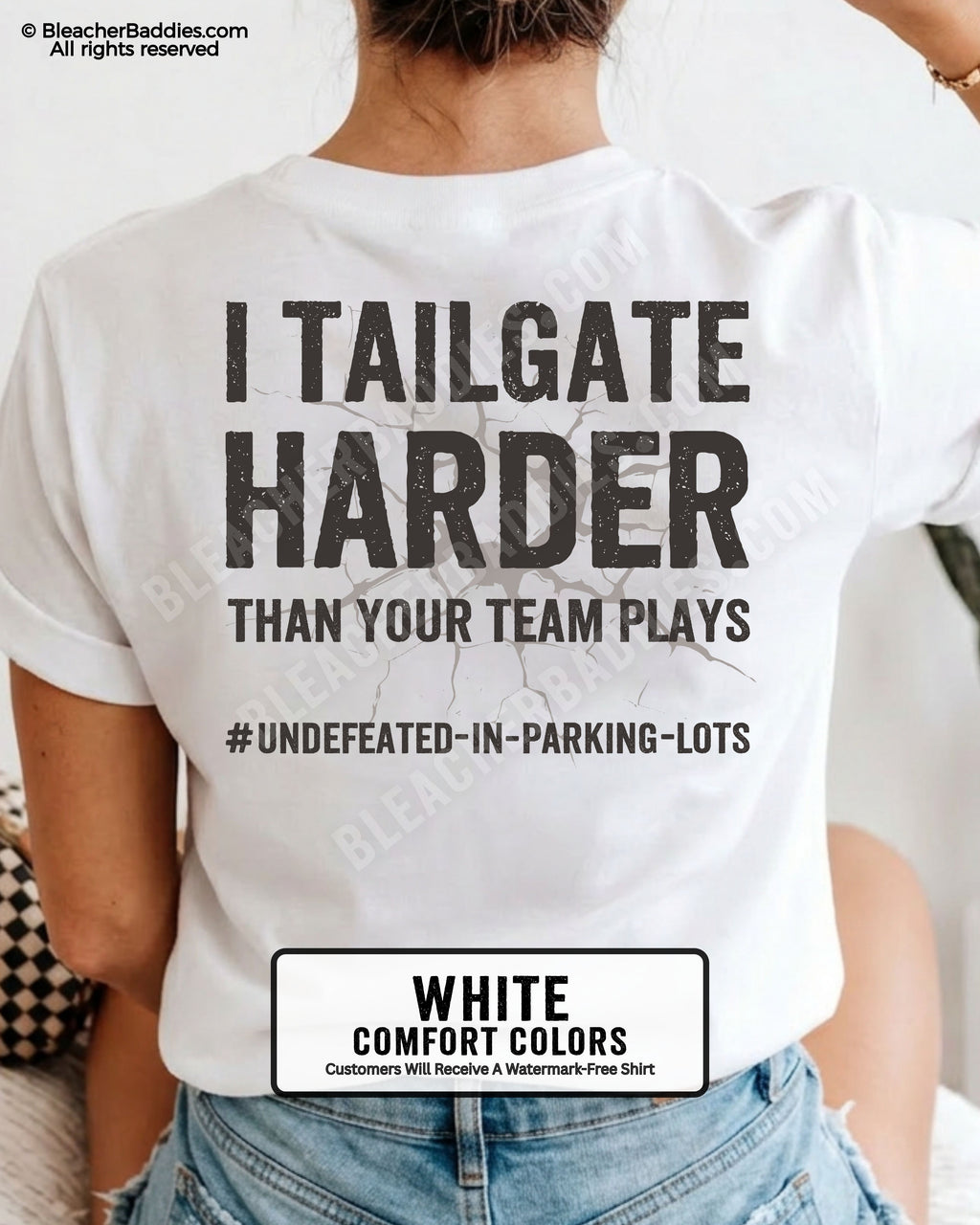 White Comfort Colors baseball mom graphic tee with distressed oversized lettering reading “I Tailgate Harder Than Your Team Plays” with hashtag “#Undefeated-In-Parking-Lots” across the back