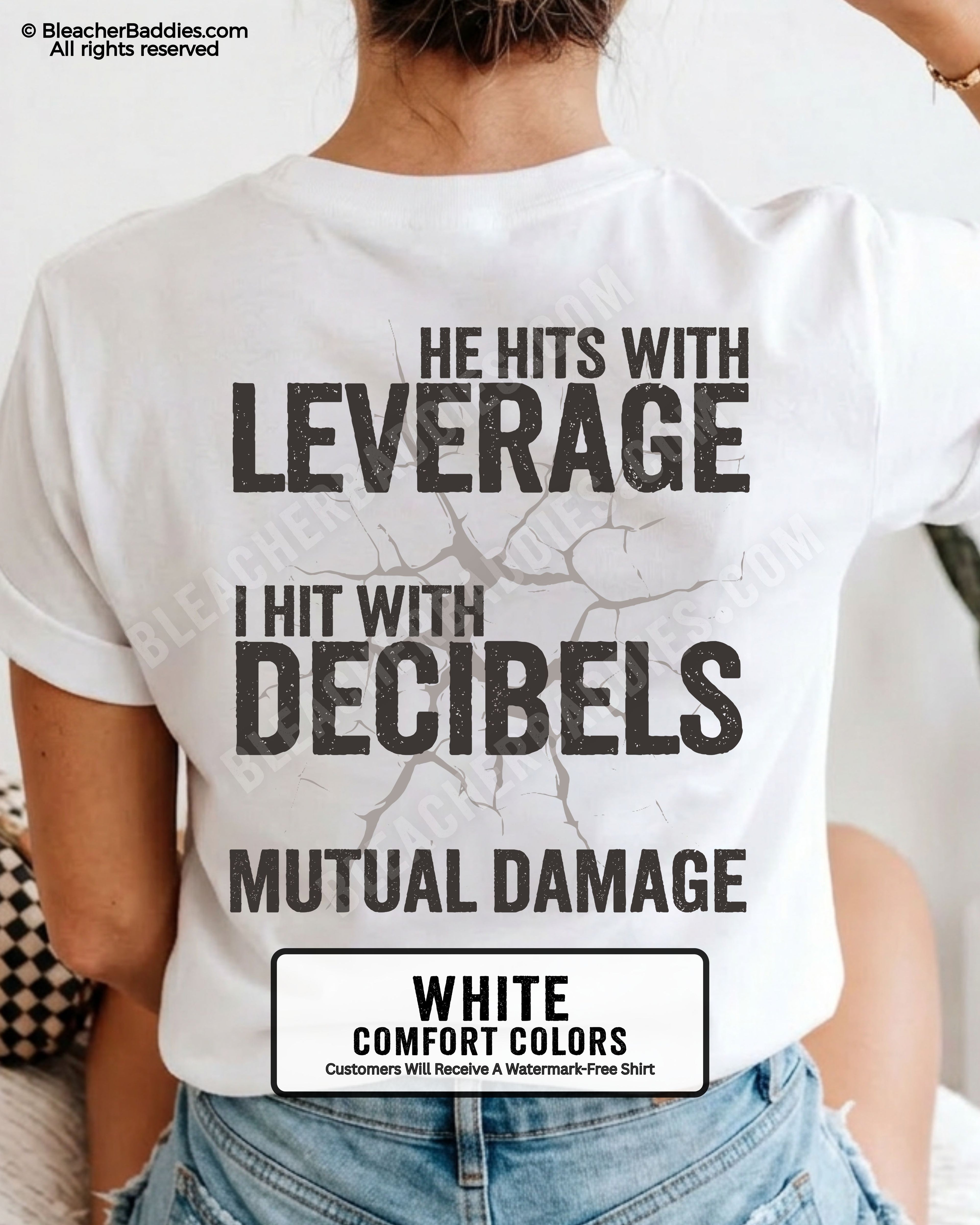 Back view of a white Comfort Colors football mom t-shirt featuring the "He Hits with Leverage, I Hit with Decibels" graphic and "Mutual Damage" printed in a distressed game day design.