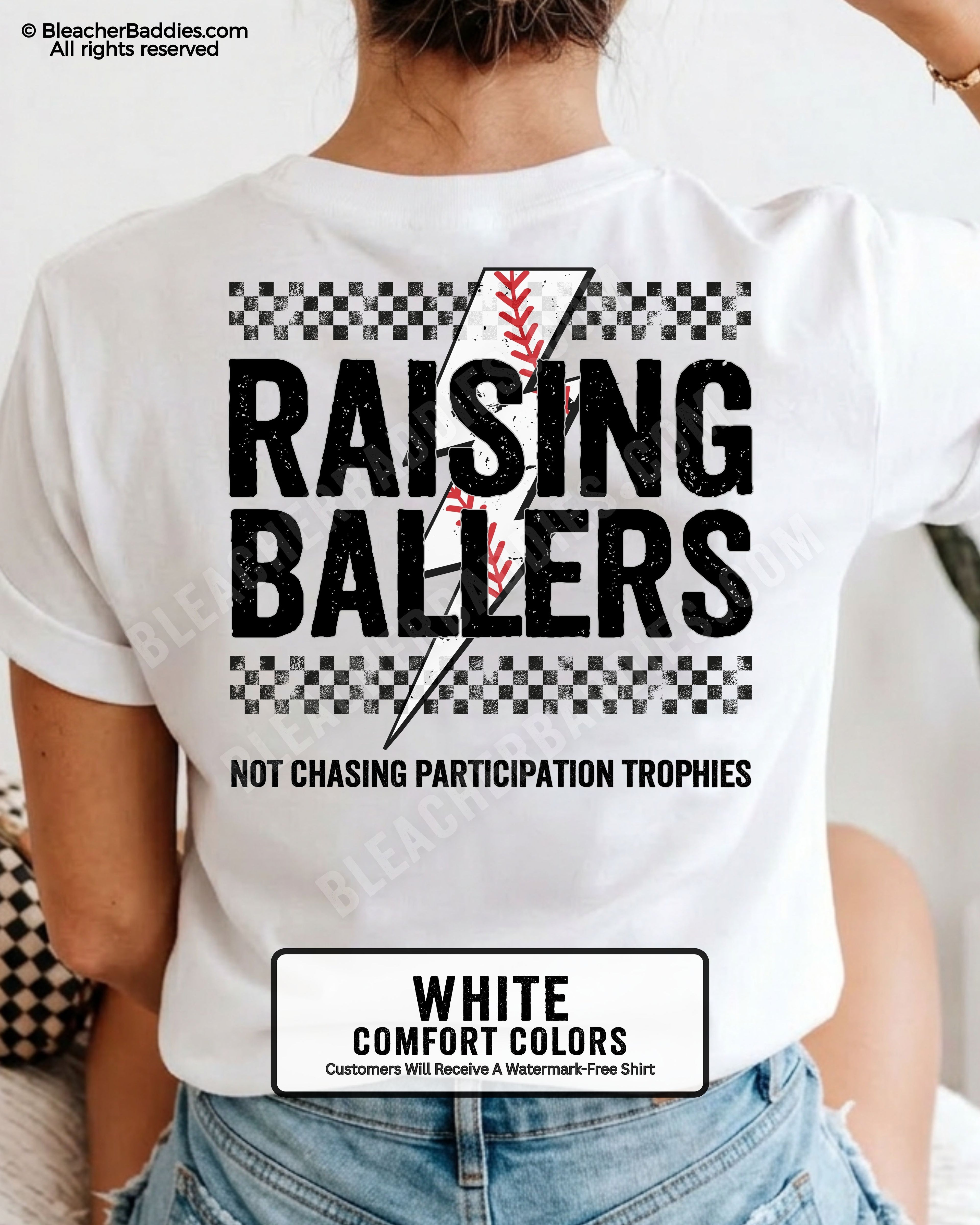 White Comfort Colors baseball mom shirt featuring a distressed Raising Ballers design with checkerboard details, red baseball stitch graphic, and bold “Not Chasing Participation Trophies” game day slogan.