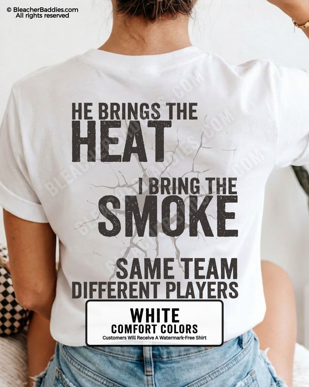 Close-up of WHITE COMFORT COLORS FOOTBALL MOM t-shirt back print showing distressed text “He Brings the Heat I Bring the Smoke Same Team Different Players” with cracked design detail