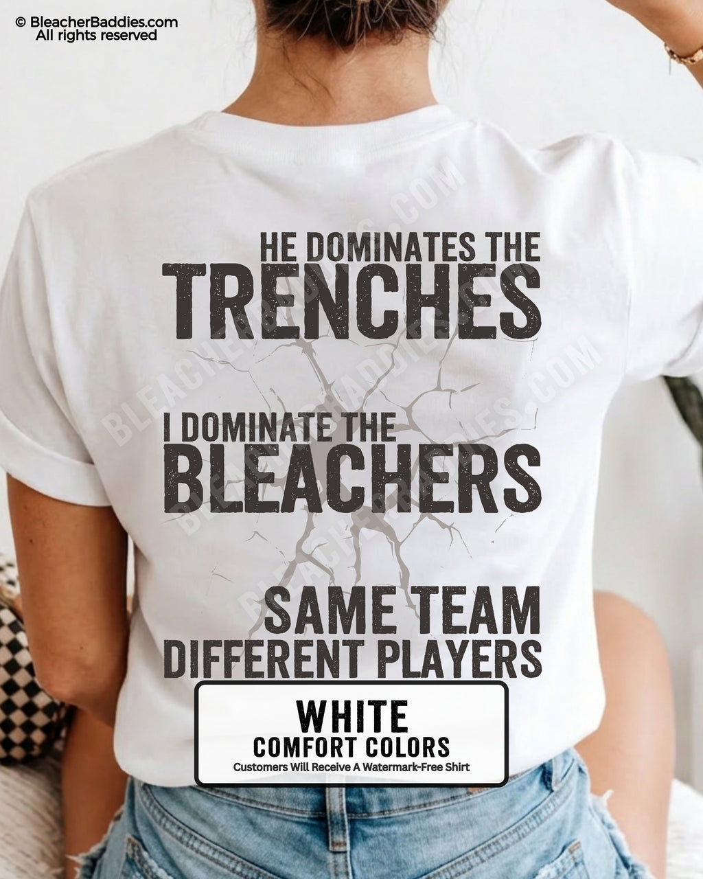 Close-up of woman wearing white comfort colors t-shirt back print with distressed text “He Dominates the Trenches I Dominate the Bleachers Same Team Different Players” and cracked design detail