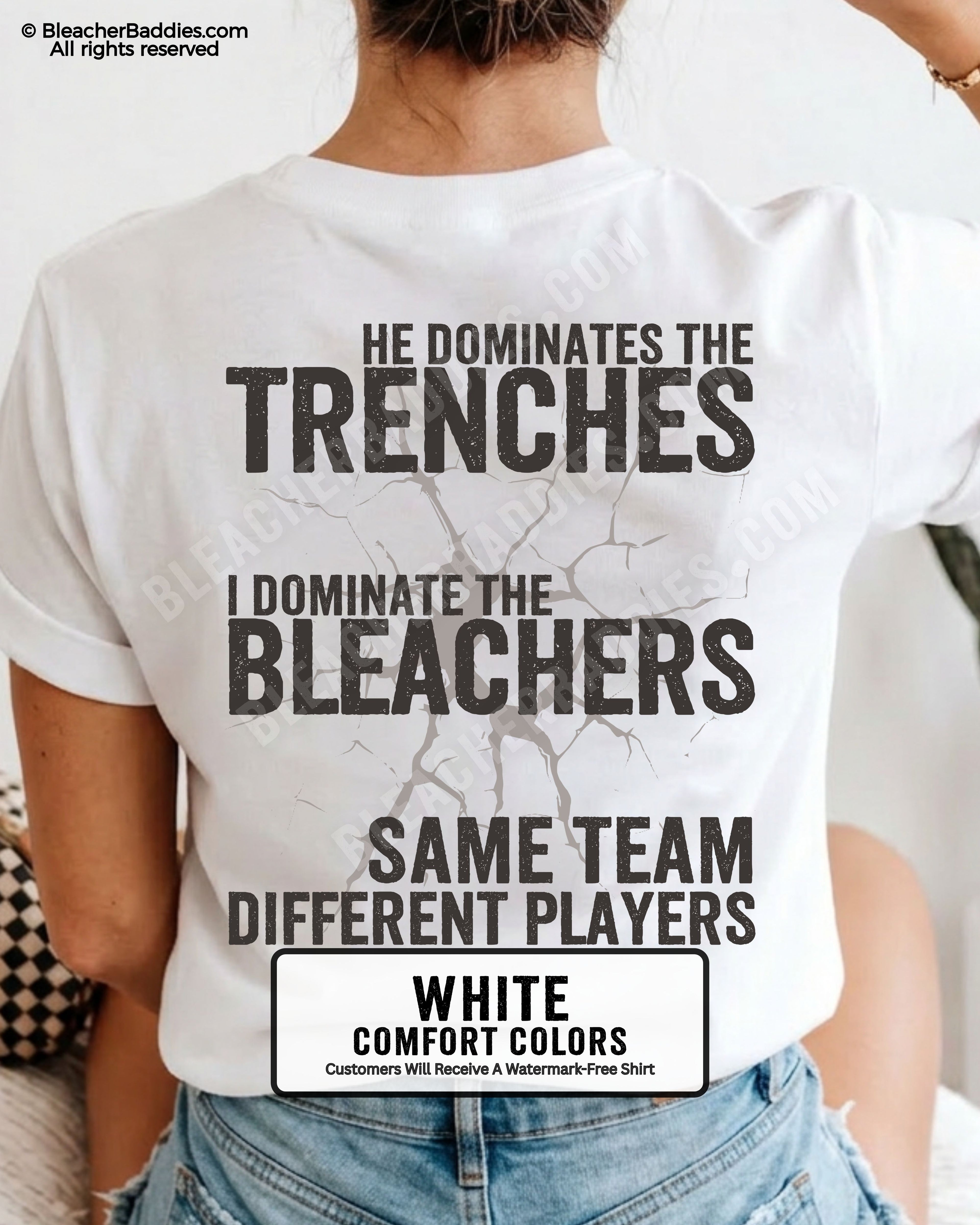 Close-up of woman wearing white comfort colors t-shirt back print with distressed text “He Dominates the Trenches I Dominate the Bleachers Same Team Different Players” and cracked design detail