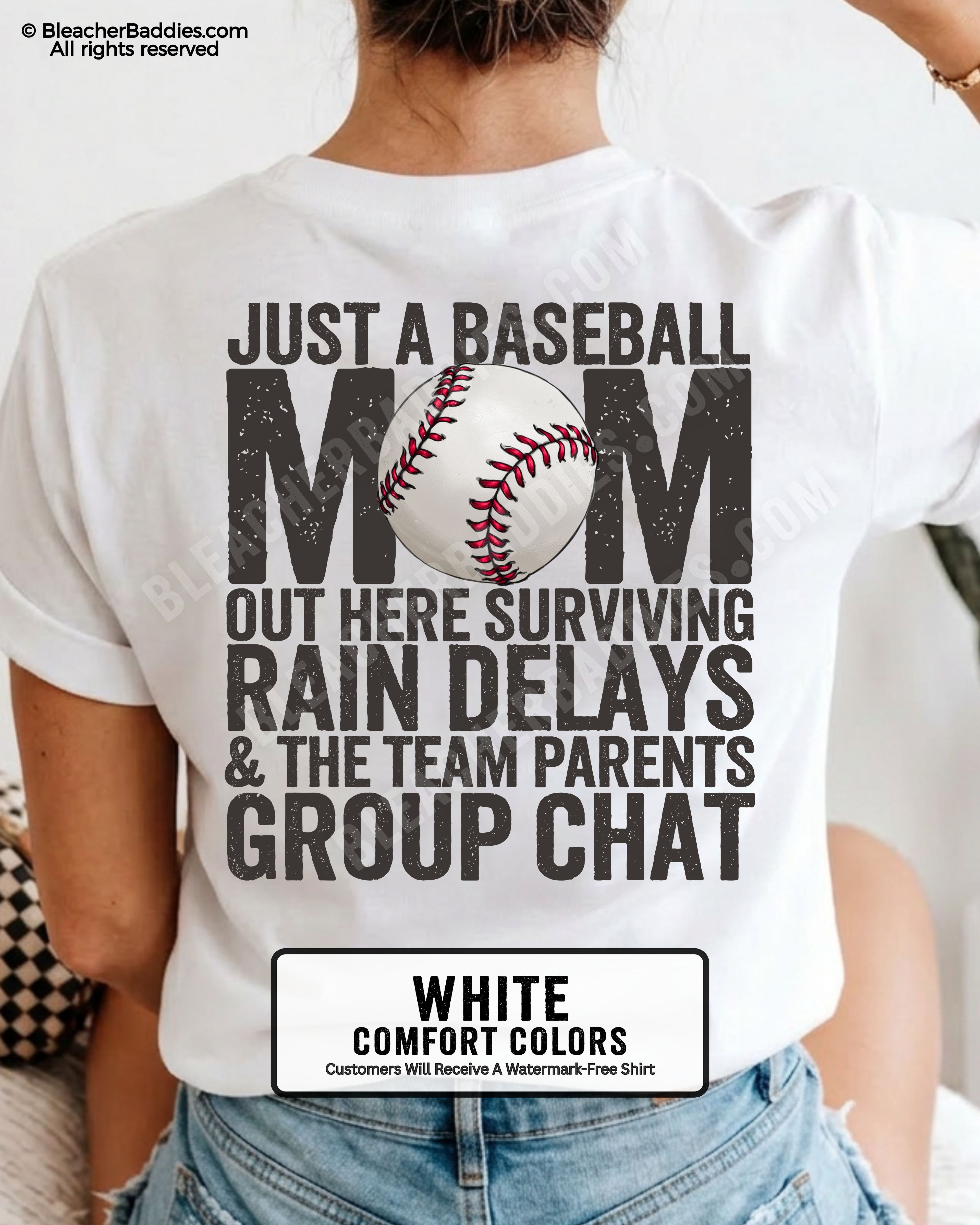White baseball mom graphic tee featuring distressed black back design reading “Just a baseball mom out here surviving rain delays and the team parents group chat” with baseball illustration centered in MOM