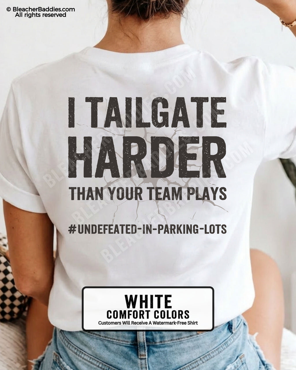 Woman wearing WHITE Comfort Colors football mom game day shirt with back design that reads “I tailgate harder than your team plays #undefeated-in-parking-lots” in distressed black text with cracked graphic and chambray color label shown