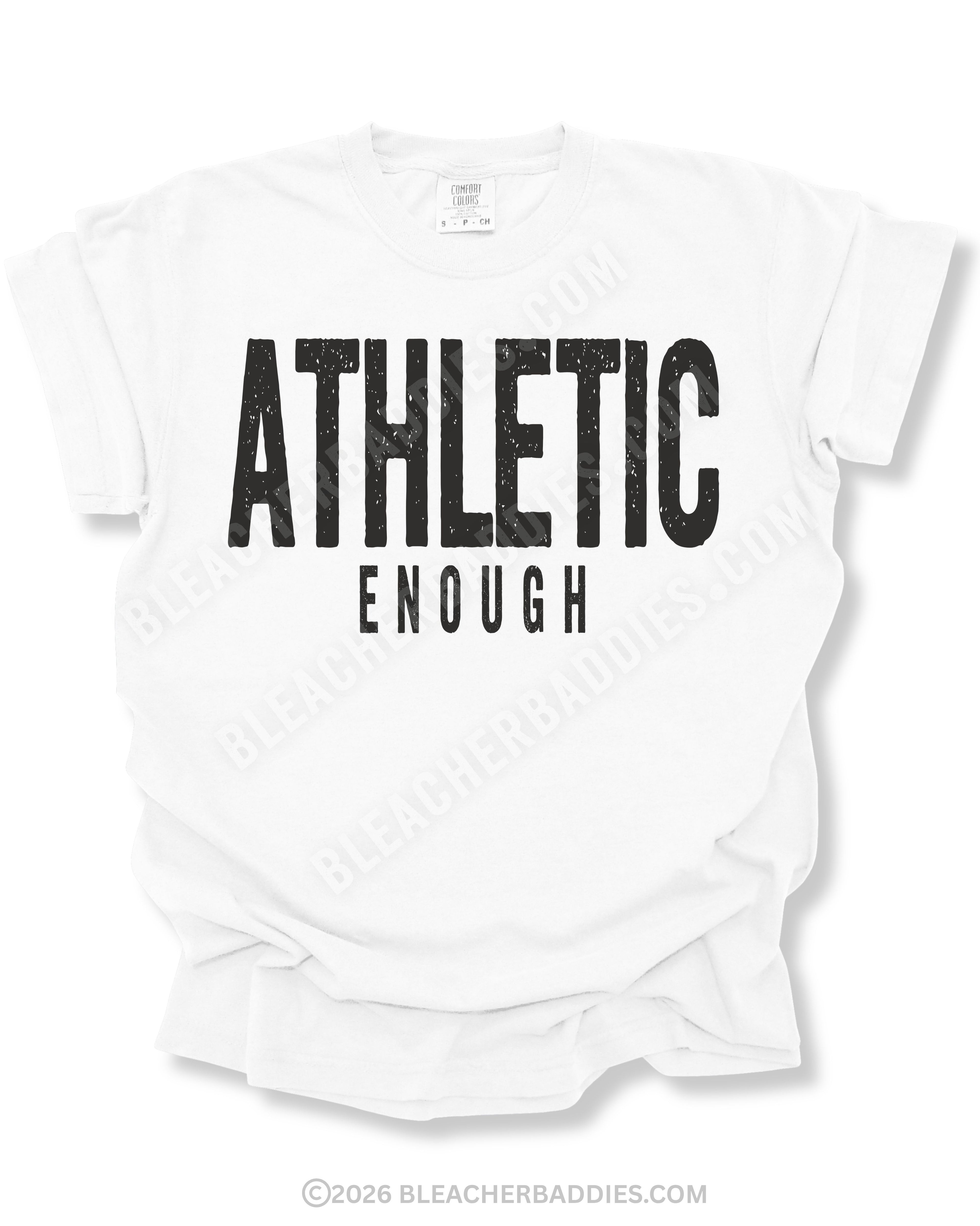 Flat lay mockup of a white Comfort Colors football shirt featuring distressed black text that reads “Athletic Enough” on a neutral gray background.
