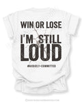 White t-shirt shown from the back featuring a large distressed black graphic that reads “Win or Lose I’m Still Loud #Audibly Committed” with a cracked texture effect.