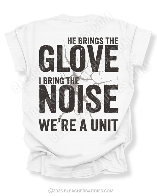 White Comfort Colors baseball mom graphic tee with distressed oversized back design reading “He Brings The Glove I Bring The Noise We’re A Unit” featuring vintage cracked effect and BleacherBaddies.com watermark across design.