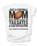 Football mom game day shirt on a white Comfort Colors tee, featuring a back graphic that says, “Just a football mom who thrives solely on tailgates & bad officiating (fully committed to this behavior).”