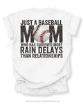 White Comfort Colors game day shirt with distressed back graphic reading “Just a Baseball Mom Who Has Survived More Rain Delays Than Relationships” with baseball graphic layered over MOM text
