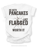 Football mom game day shirt with back design that reads “He gets pancakes I get flagged worth it” in distressed black text with a cracked impact graphic on a white tee