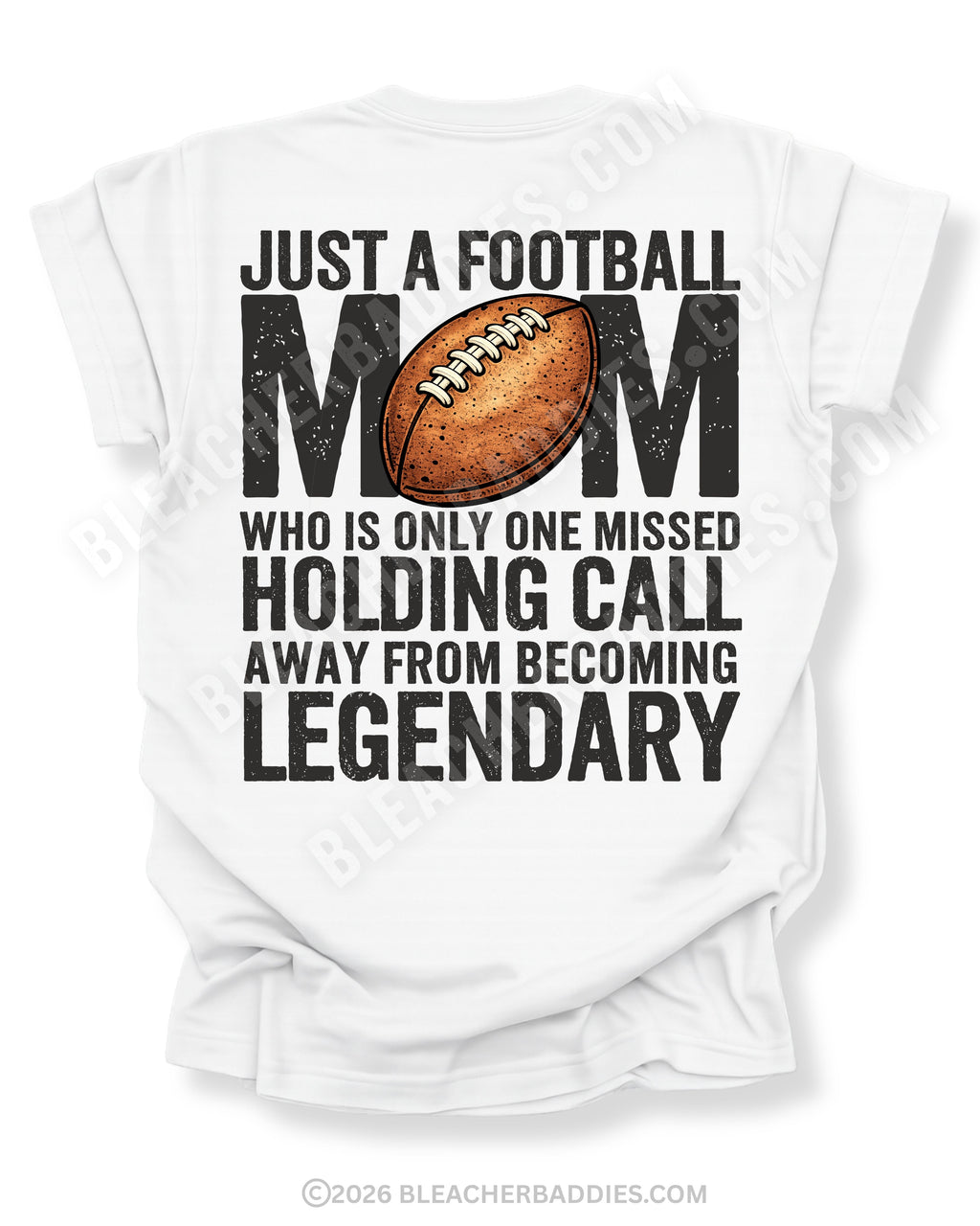 White Comfort Colors t-shirt with back graphic reading “Just a football mom who is only one missed holding call away from becoming legendary” with football illustration
