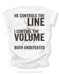 Back view of white Comfort Colors football mom game day shirt featuring “He Controls the Line I Control the Volume Both Undefeated” bold graphic design