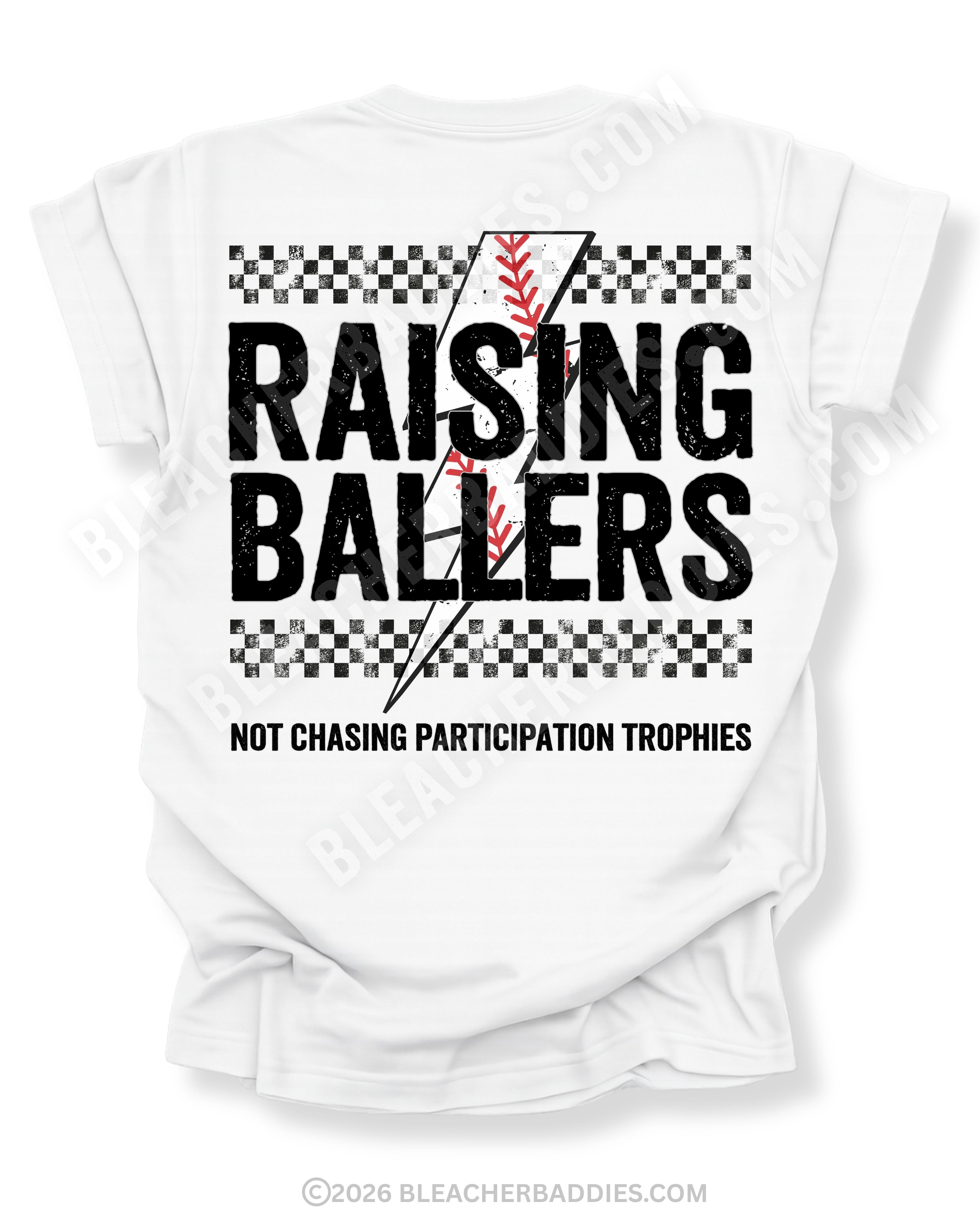 White Comfort Colors Raising Ballers shirt with oversized distressed baseball graphic, black checkerboard stripes, red baseball stitching, and “Not Chasing Participation Trophies” slogan on the back.