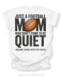 Football mom game day shirt flat lay on white Comfort Colors tee featuring bold back graphic that reads “Just a football mom who didn’t come to be quiet volume comes with the seat”