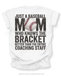 White baseball mom game day shirt with distressed black text reading “Just a baseball mom who knows the bracket better than the entire coaching staff” and baseball graphic replacing the O in MOM