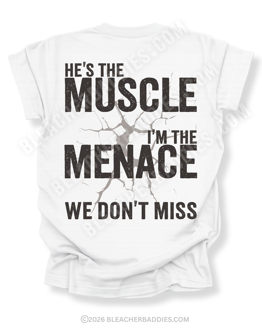 White Comfort Colors football mom game day shirt flat lay with back design that reads “He’s the muscle I’m the menace we don’t miss” in distressed black text with cracked impact graphic
