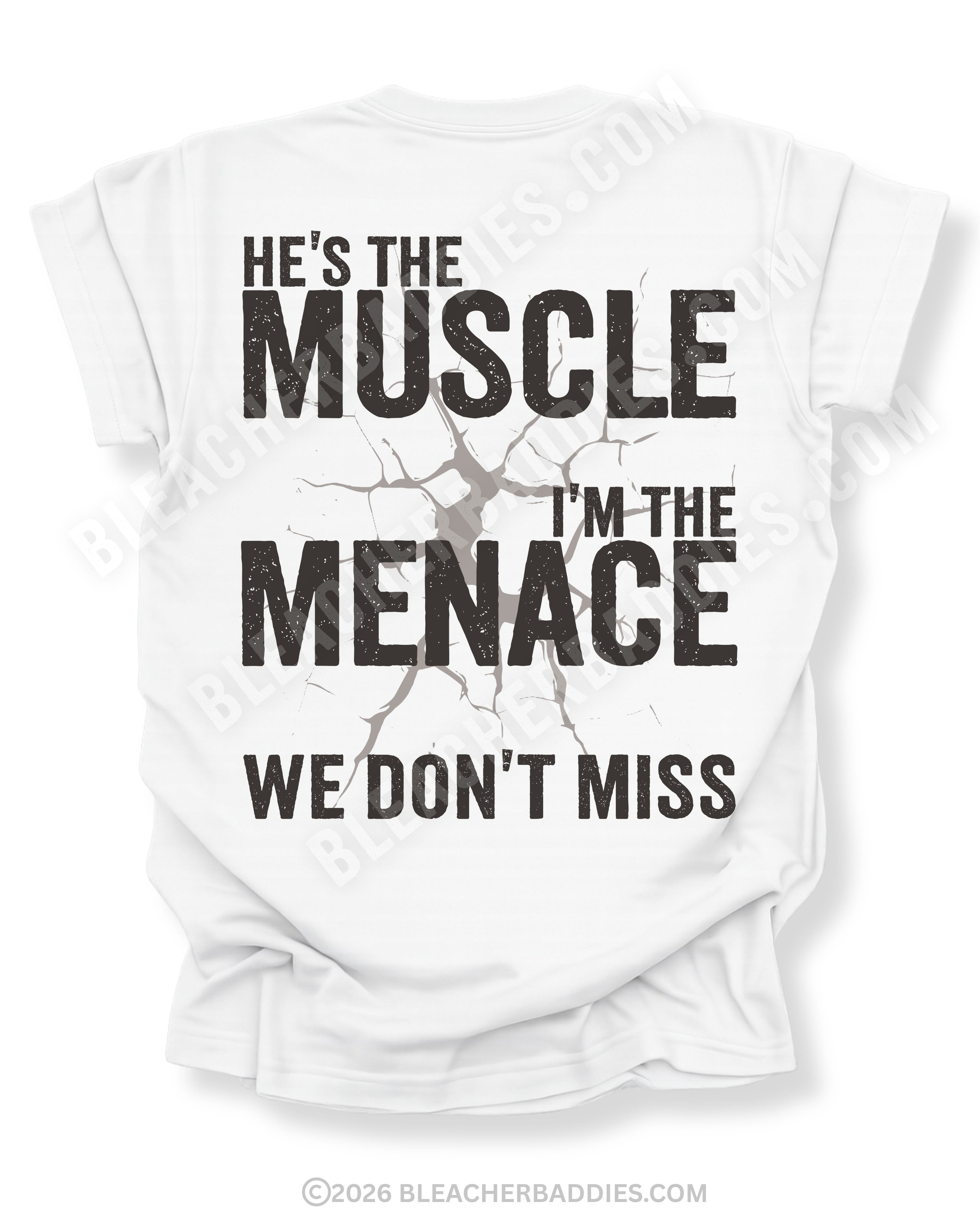 White Comfort Colors football mom game day shirt flat lay with back design that reads “He’s the muscle I’m the menace we don’t miss” in distressed black text with cracked impact graphic