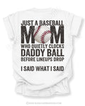 White Comfort Colors game day shirt with distressed back graphic reading “Just a Baseball Mom Who Quietly Clocks Daddy Ball Before Lineups Drop I Said What I Said” with baseball graphic layered over MOM text