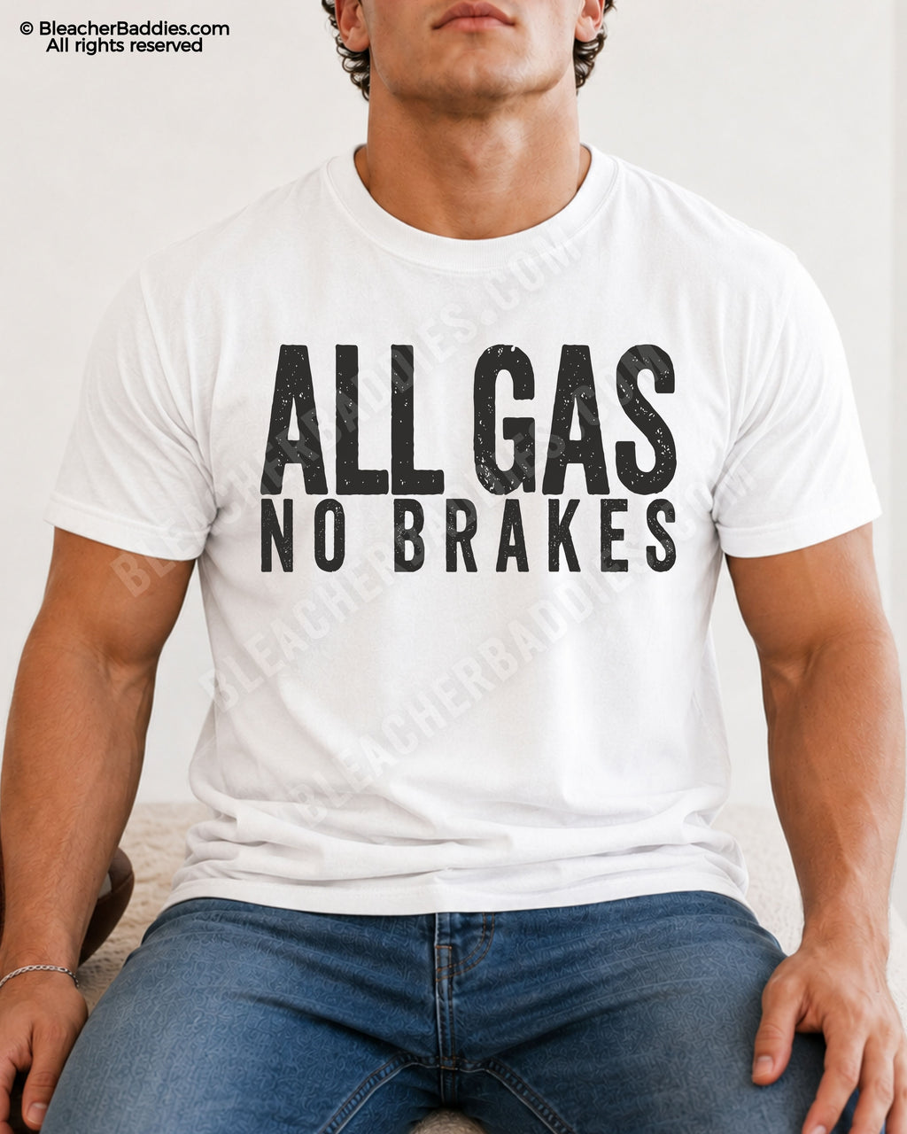 Male football player model sitting indoors wearing a white oversized football shirt with bold distressed “ALL GAS NO BRAKES” typography and relaxed game day styling.