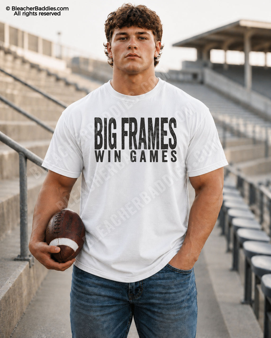Football player standing in stadium wearing a white Comfort Colors “Big Frames Win Games” game day shirt with distressed black lettering and football aesthetic.